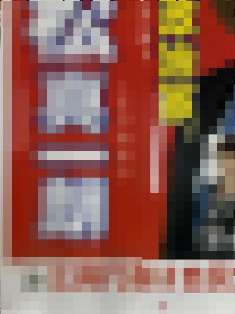 Very blurry image of a red sign or poster with white/gray areas; details are unreadable in this pixelated view.